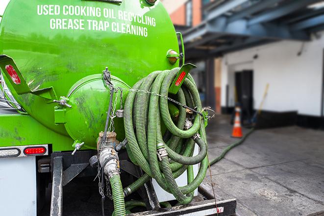 a grease trap being pumped by a sanitation technician in Carr, CO